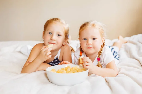 Girls eating corn puffs — Stock Photo, Image