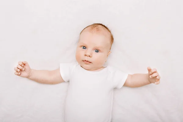 Bebé con ojos grises azules acostado —  Fotos de Stock