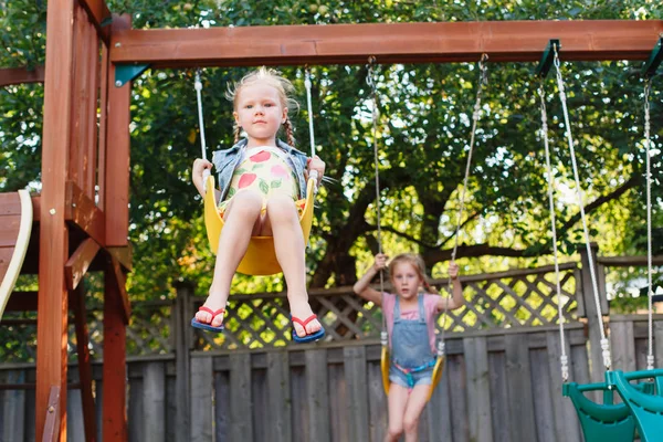 Leende små flickor på swing — Stockfoto