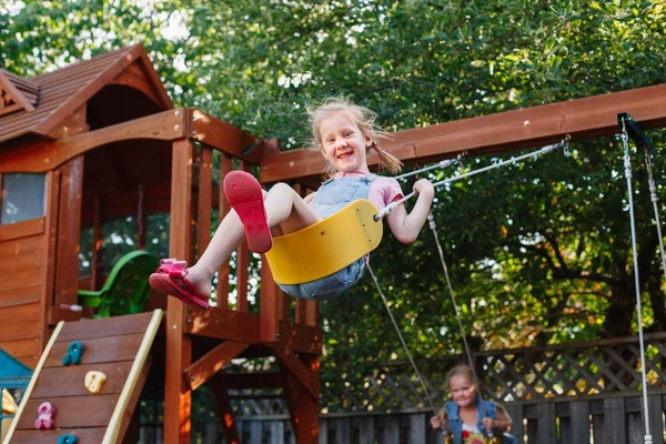 Leende små flickor på swing — Stockfoto