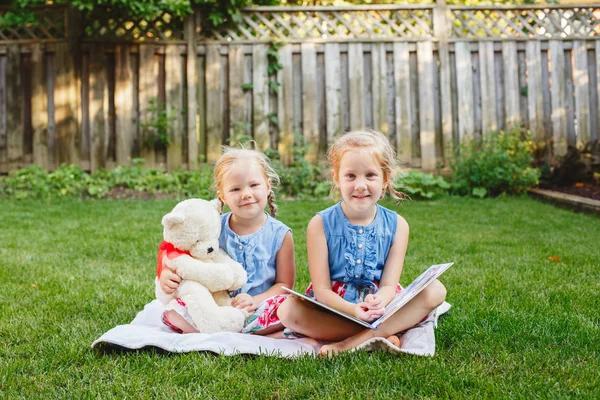 Niños amigos sentados con libro —  Fotos de Stock
