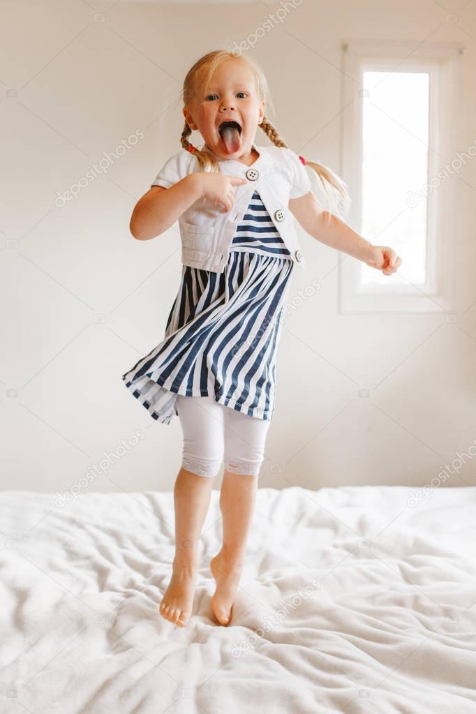 girl jumping on bed