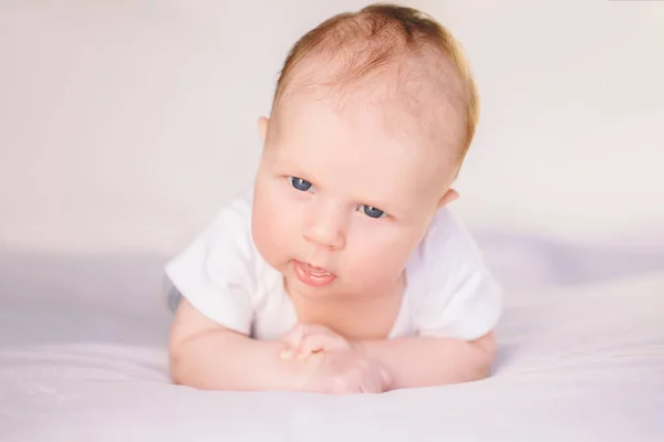 Bambino caucasico sul letto — Foto Stock