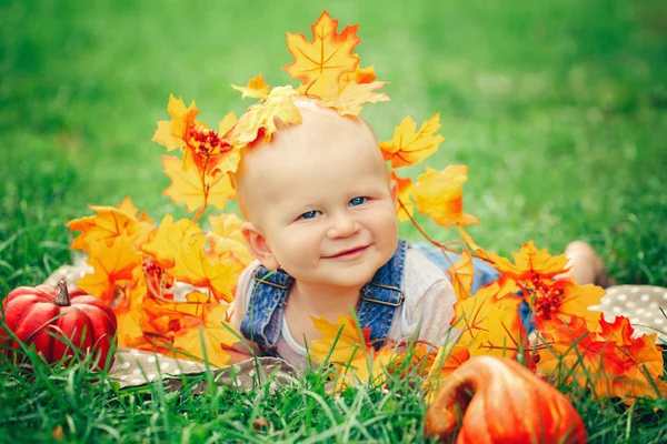 Baby in yellow autumn leaves — Stock Photo, Image
