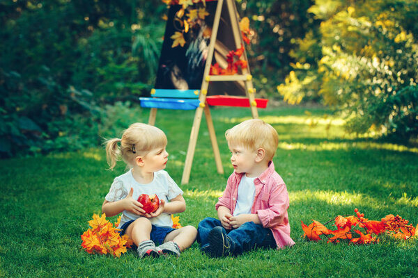 Boy and girl sitting in park 