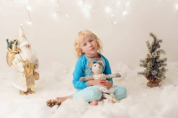 Enfant caucasien fille aux yeux bleus assis avec des jouets célébrant Noël ou Nouvel An vacances — Photo