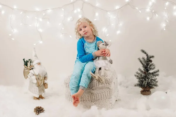 Anak perempuan Kaukasia dengan mata biru duduk dengan mainan merayakan Natal atau Tahun Baru liburan — Stok Foto