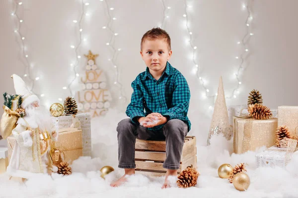 Potret anak laki-laki cantik berkulit putih yang tampan dan tampan dengan mata berwarna coklat dengan kemeja hijau dan celana jeans yang merayakan Natal atau Tahun Baru — Stok Foto