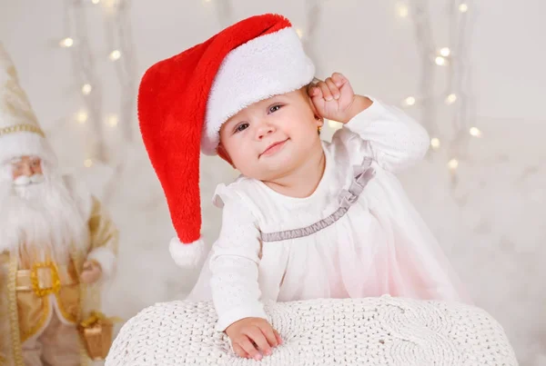 Porträt eines blonden kaukasischen Mädchens mit blauen Augen, das Weihnachtsmann-Hut trägt und Weihnachten oder Neujahr feiert — Stockfoto