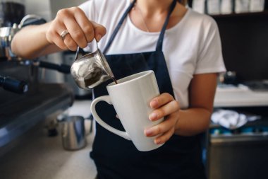Closeup makro çekim Kafkas kadın el kahve yapma. Beyaz kupa Kupası'nda sıcak kahve dökülen Barista