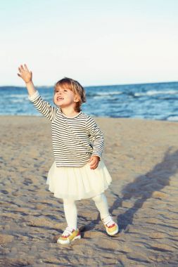 Bir komik ağlama çığlık beyaz beyaz çocuk çocuk bebek okyanus deniz plaj açık havada gün batımında çizgili gömlekli portresi. Mutlu yaşam tarzı çocukluk kavramı. Küçük kız bir şey kaybetti