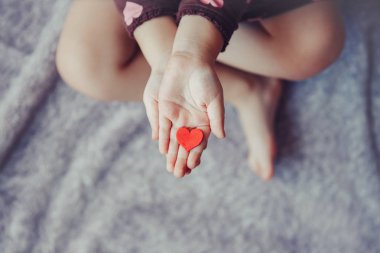 Closeup makro yetişkin üst çocuğun palms bir grup küçük kırmızı ve mor kağıt köpük kalplerin tutan eller. Yaşam tarzı ve mutlu çocukluk kavramı. Sevgililer günü kutlama. 