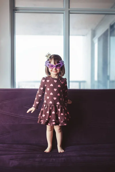 Портрет Милої Чарівної Маленької Дівчинки Смішними Окулярами Стрибають Танцюючи Дивані — стокове фото
