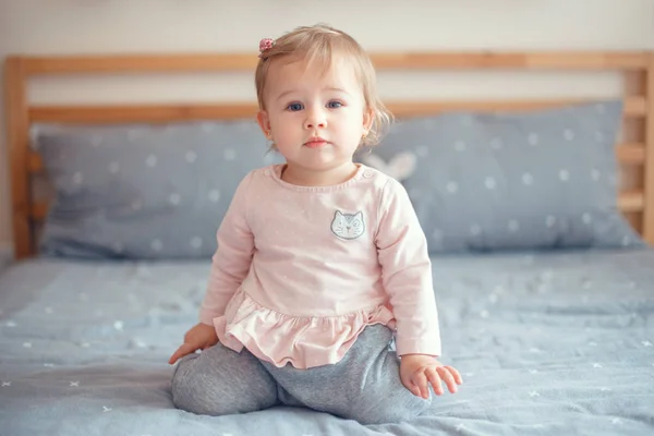 可爱的白人金发碧眼的小女孩的肖像 在卧室的床上坐在粉红色的粉红衬衫 自然情感表情 快乐的童年生活理念 — 图库照片
