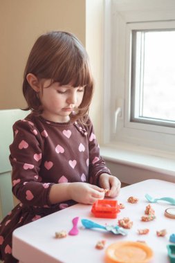 Hamuru playdough kapalı evde oynamak sevimli beyaz beyaz iskambil kız portresi. Erken yaratıcılık beyin geliştirme kavramı. Çocuk aktivite. İnce motor becerileri.