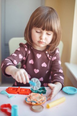 Hamuru playdough kapalı evde oynamak sevimli beyaz beyaz iskambil kız portresi. Erken yaratıcılık beyin geliştirme kavramı. Çocuk aktivite. İnce motor becerileri.