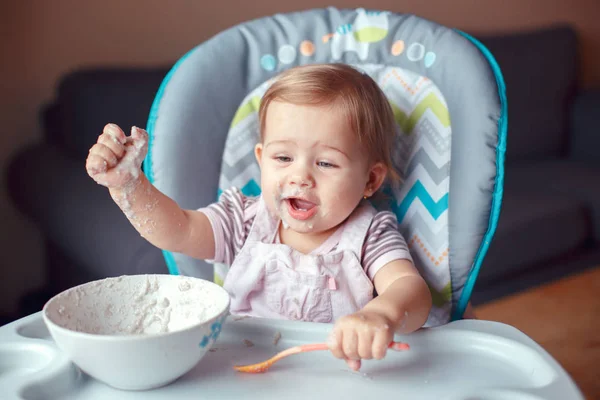 かわいい愛らしい白人の子供子供女の子スプーンで穀物を食べて高椅子に座っての肖像画 日常のライフ スタイル 率直な本格瞬間 — ストック写真