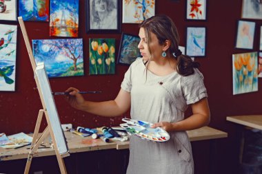 Genç güzel orta yaş beyaz beyaz kadın sanatçı sanat Studio akrilik boya ile resim çizim tuvali üzerinde portresi. Yaşam tarzı etkinlik hobi kavramı