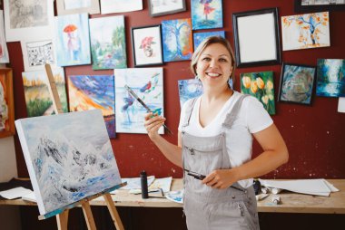 Genç güzel orta yaş beyaz beyaz kadın sanatçı sanat Studio akrilik boya ile resim çizim tuvali üzerinde portresi. Yaşam tarzı etkinlik hobi kavramı