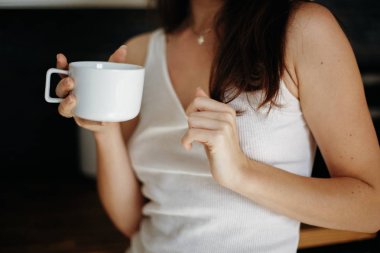 Güzel genç seksi beyaz bir kadın koyu Kızıl saçlı beyaz tshirt kahve içme mutfakta giyen closeup. Doğal güzellik gençlik bak. Kız iç çamaşırı evde