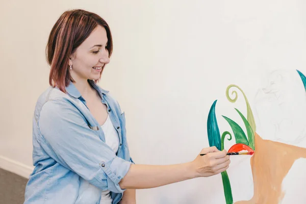 生活方式 创意爱好和自由职业艺术创作的兼职概念 在公寓或工作室学校的墙壁上 白种人女画家手绘壁画 涂上丙烯酸颜料 — 图库照片