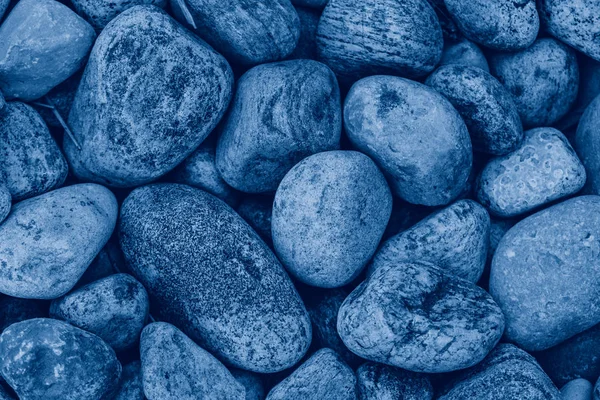 Closeup macro of big huge large blue stones rocks pebbles lying on ground. Natural eco environmental background texture. View from top above. Toned with classic blue 2020 color. — Stock Photo, Image