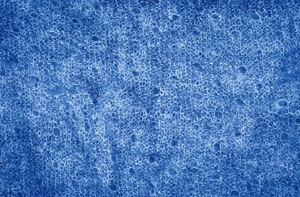 Primer plano macro textura de punto oscuro clásico chal de tela de lana azul. Texturizado fondo de la ropa con arrugas y pliegues. Tonificado con el color de moda 2020 año azul . — Foto de Stock