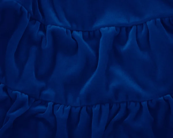 Zbliżenie klasyczny niebieski makro tekstury niebieskiego aksamitnego materiału lub odzieży. Toned modny 2020 roku tło kolor z zmarszczek i fałdy. ciemnoniebieskie monochromatyczne tło tapety. — Zdjęcie stockowe