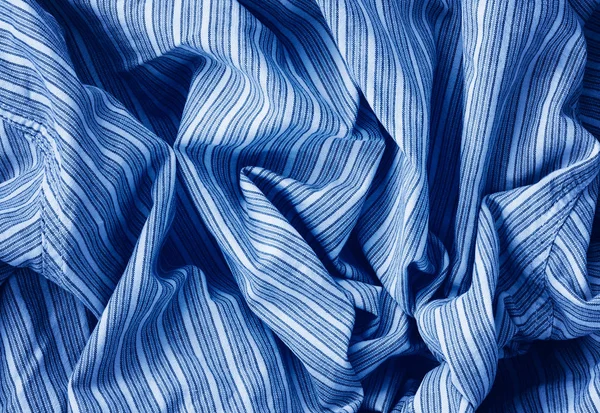 Closeup classic blue macro texture of blue linen cotton material fabric with stripes. Toned trendy 2020 year color background with wrinkles and folds. Dark blue monochrome backdrop wallpaper. — ストック写真