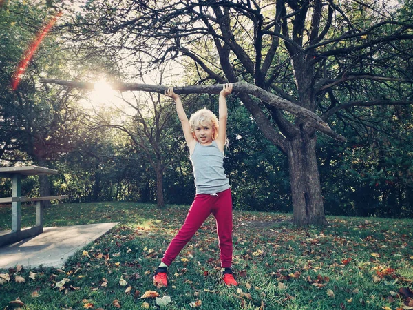 Sporty healthy strong young girl lifting wooden stick branch log — Stock Photo, Image