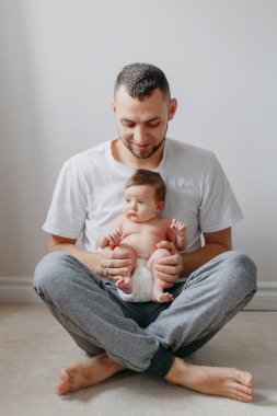 Yeni doğmuş bebeği kucağında tutan mutlu beyaz bir baba. Man p