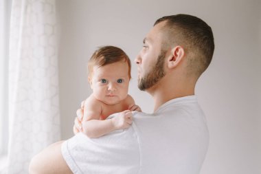 Yeni doğmuş bebeği tutan mutlu beyaz bir baba. Erkek sakallı adam.