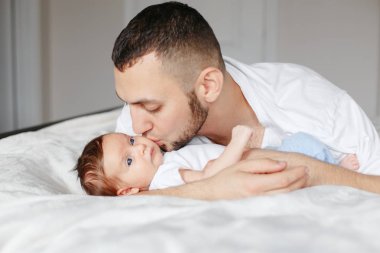 Yeni doğmuş bebeği tutan mutlu beyaz bir baba. Erkek sakallı adam.
