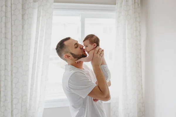 Ayah Kaukasia bahagia mencium bayi yang baru lahir. Pria orang tua hol — Stok Foto