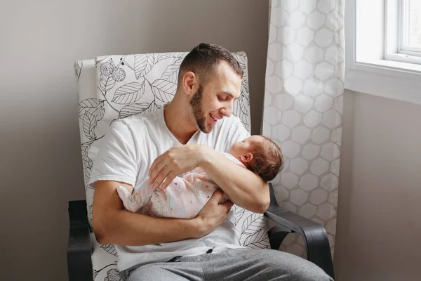 Kaukázusi apa ül karosszékben újszülött kislány fiú. — Stock Fotó