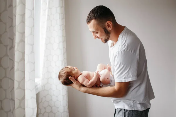 Feliz padre caucásico sosteniendo al bebé recién nacido. Hombre barbudo hombre pa — Foto de Stock