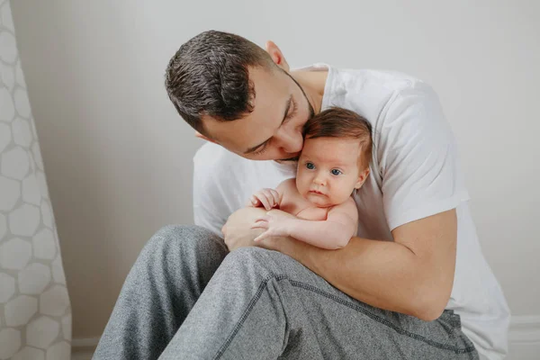 Щасливий кавказький батько, який тримає новонароджену дитину на колінах. Людина Р — стокове фото