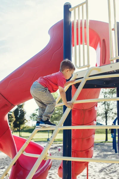 Ativo criança menino caucasiano valente feliz escalada escada — Fotografia de Stock