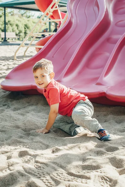 Ativo feliz engraçado sorrindo caucasiano menino criança deslizando no playgr — Fotografia de Stock