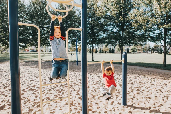 Jóvenes caucásicos chicos amigos colgando en barras de mono y pull-up — Foto de Stock