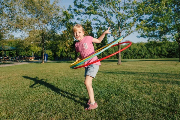 Cute smiling Caucasian preschool girl playing with hoola hoop in — 스톡 사진