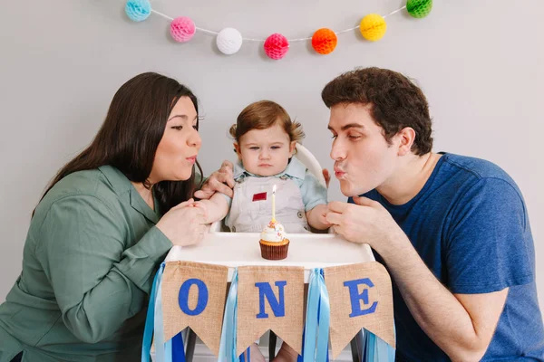 Keluarga Kaukasia dengan bayi laki-laki merayakan ulang tahun pertamanya di rumah. Ibu ayah dengan anak balita meniup lilin di atas kue mangkok. Selamat ulang tahun dan kue menghancurkan konsep. — Stok Foto