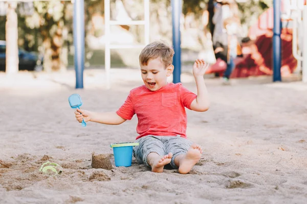 Duas crianças caucasianas sentadas em sandbox brincando com brinquedos de praia. Pequena menina e meninos amigos se divertindo juntos no playground. Atividade ao ar livre de verão para crianças. Tempo de lazer estilo de vida infância . — Fotografia de Stock