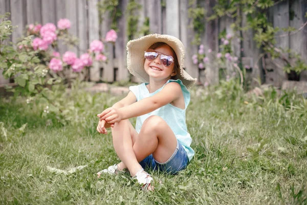 Портрет Милой Очаровательной Девочки Солнечных Очках Соломенной Шляпе Сидящей Траве — стоковое фото