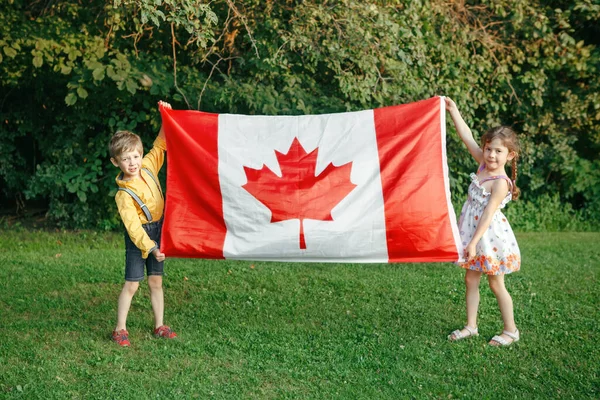 Anak Laki Laki Dan Perempuan Kaukasia Mengibarkan Bendera Kanada Besar — Stok Foto