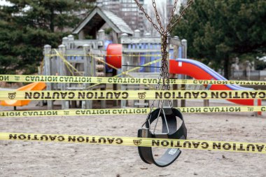 Toronto, Ontario, Kanada - 26 Mart 2020: kapalı açık hava oyun alanı. Çocuklar, insanların toplanmasını engellemek için sarı bantla kilitli oynuyorlar. Coronavirus sosyal mesafe karantinası.