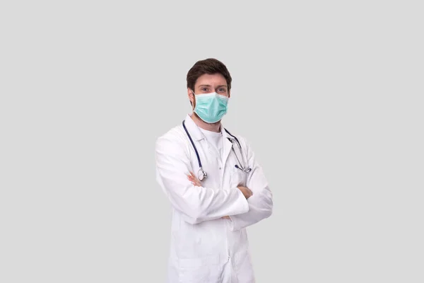 Doctor dragen van medische masker handen gekruist geïsoleerd. — Stockfoto