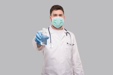 Doktor, elleri dezenfekte eden, tıbbi maske takan adam. Eller antiseptiği yıkar. Corona Virüsü Konsepti
