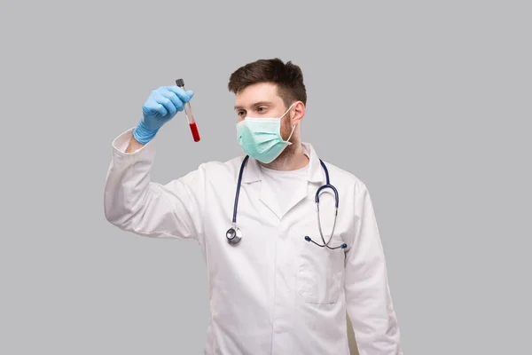 Mannelijke dokter checkt bloedanalyse draagt medische maskers en handschoenen. Dokter geïsoleerd — Stockfoto