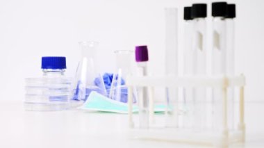 Laboratuvarda boş test tüpleri ve şişeler. Masada Tıbbi Maske, Gözlük ve Eldiven. Virüs, Bilim, Tıbbi Konsept. Yakın çekim. Odaklan. Tüpleri çek.